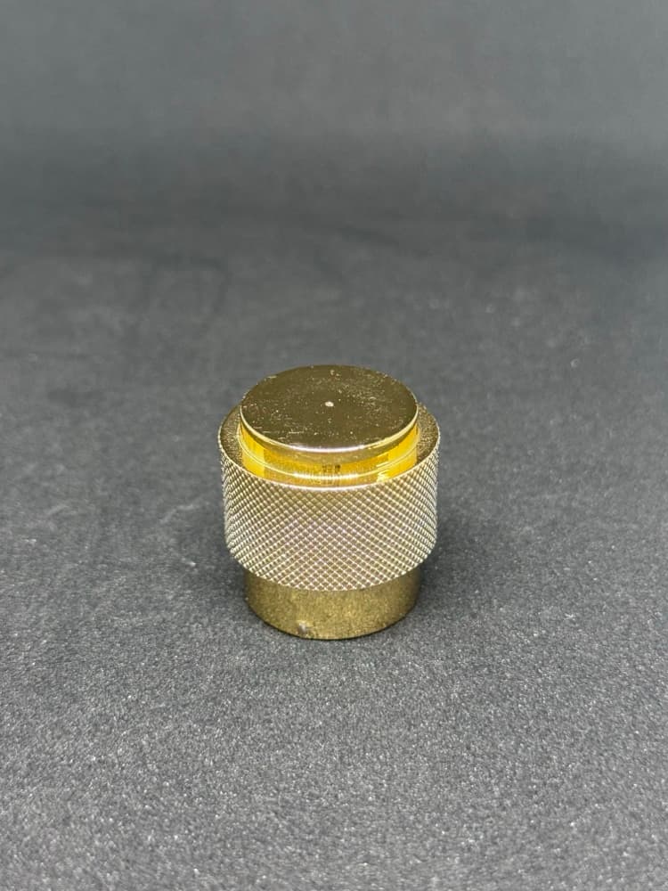 Gold knurled metal cap with a fine textured grip